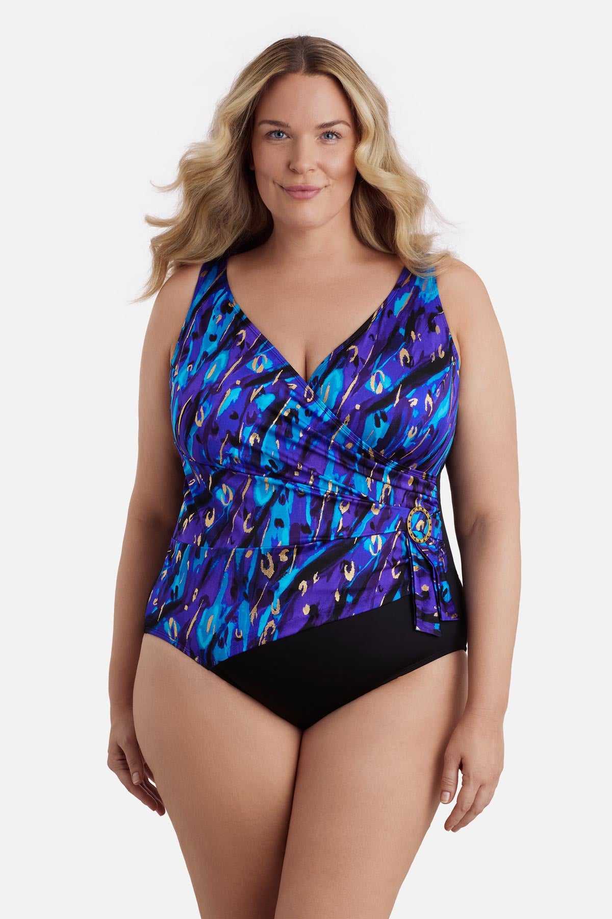 Woman wearing a blue and gold abstract printed one-piece swimsuit with a buckle sash