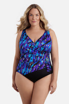 Woman wearing a blue and gold abstract printed one-piece swimsuit with a buckle sash
