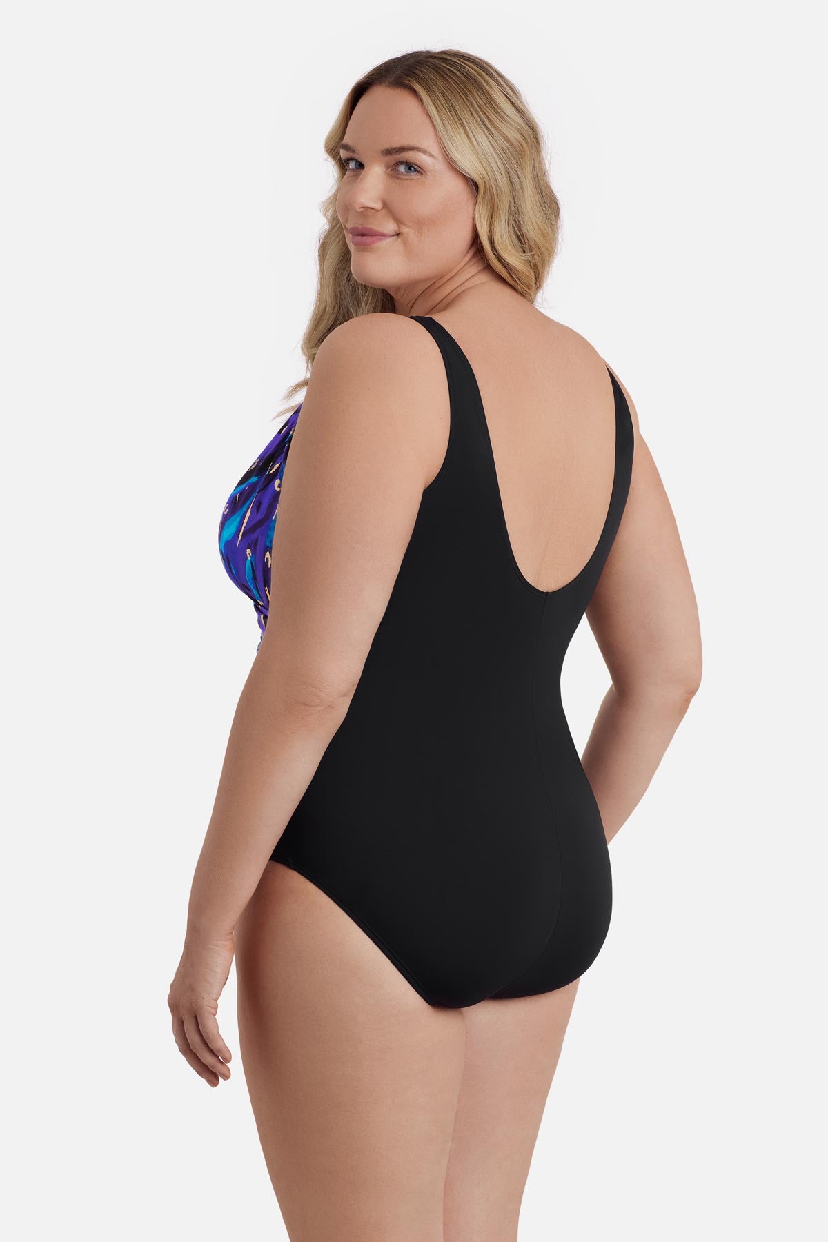 Woman faced left wearing a blue and gold abstract printed one-piece swimsuit 
