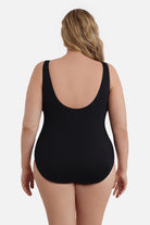 Woman faced away wearing a black one-piece swimsuit