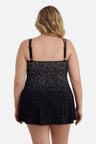 Woman faced away wearing a black and white dot print swim dress