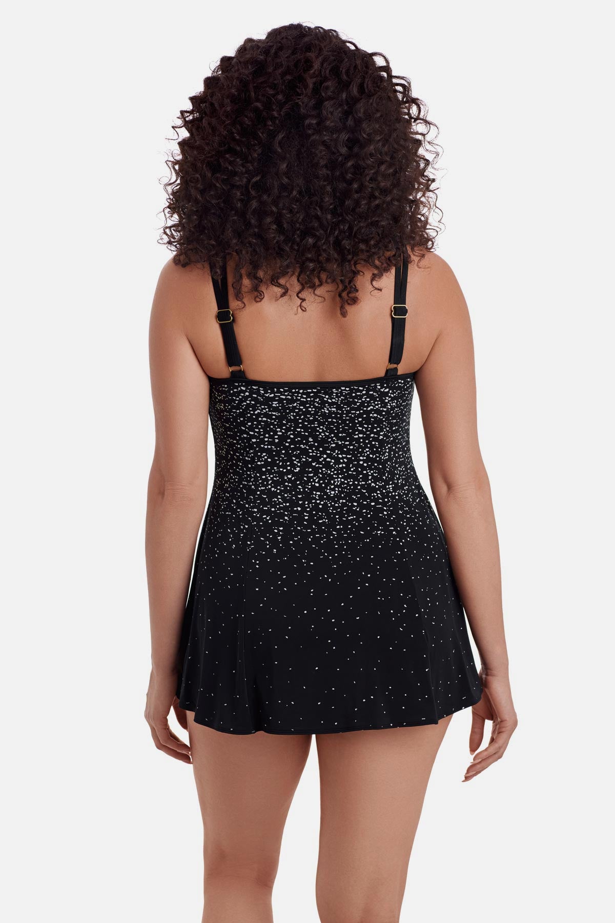 Woman turned away wearing a black and white speckled swim dress 