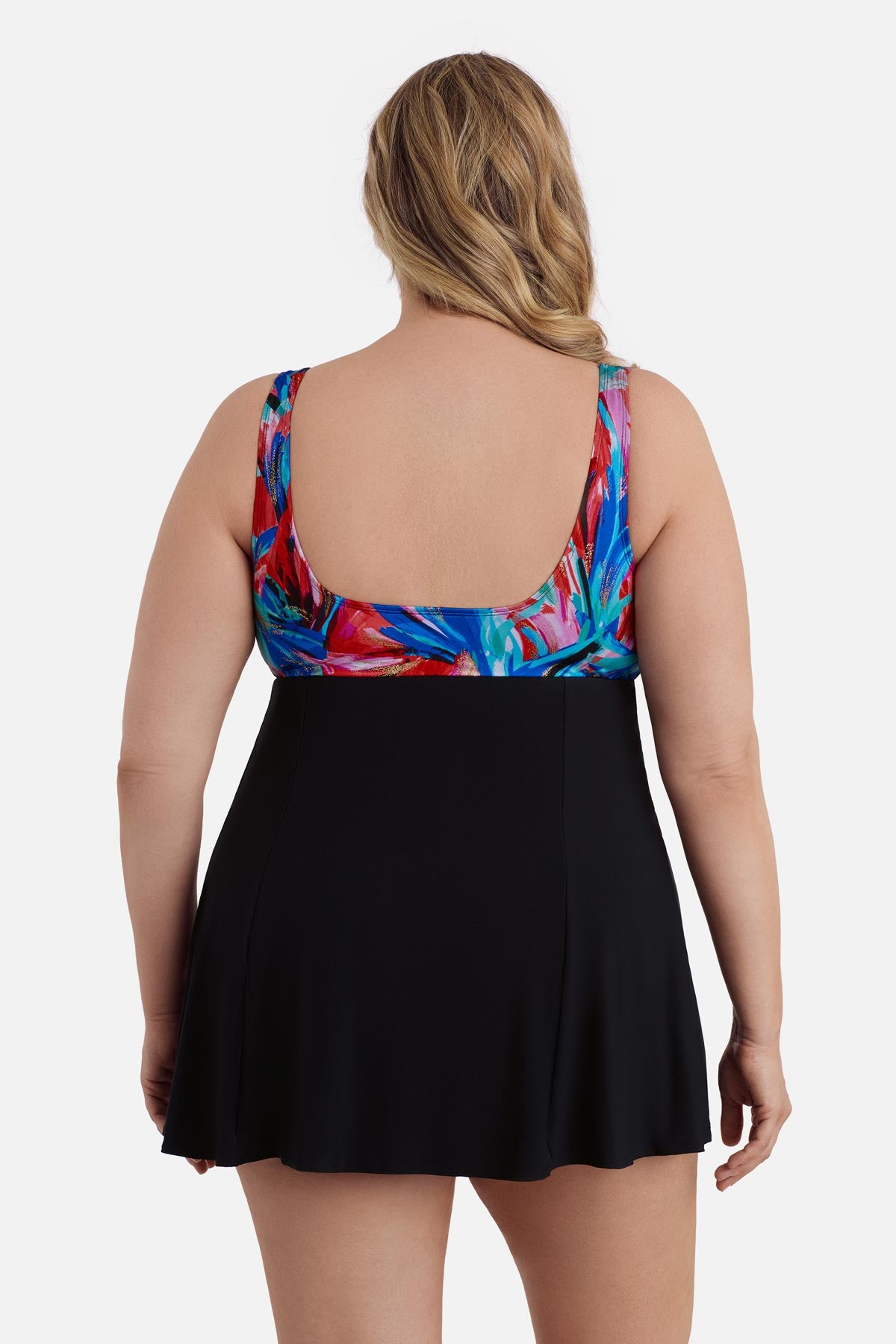 Woman turned away wearing a multicolored abstract print at the bust of the swim dress