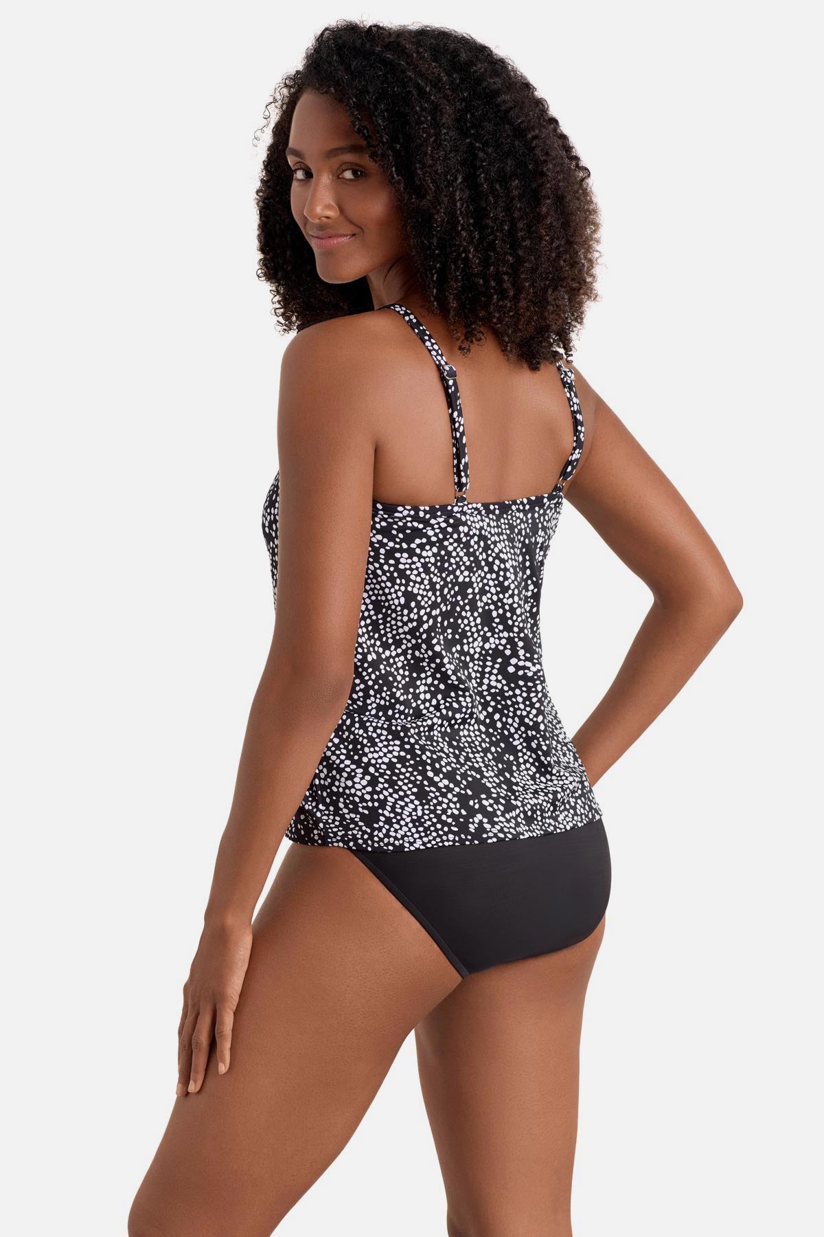 Woman turned left wearing a black and white dot printed high neck tankini top