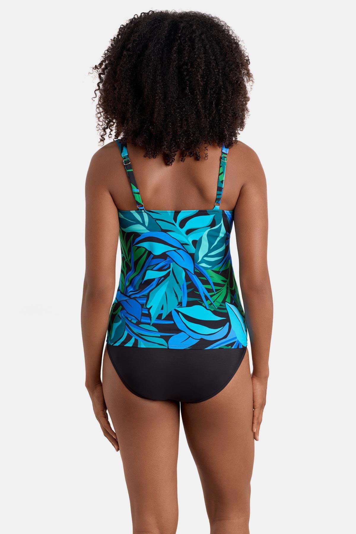 Woman turned away wearing a blue and green palm leaf print square neck tankini top