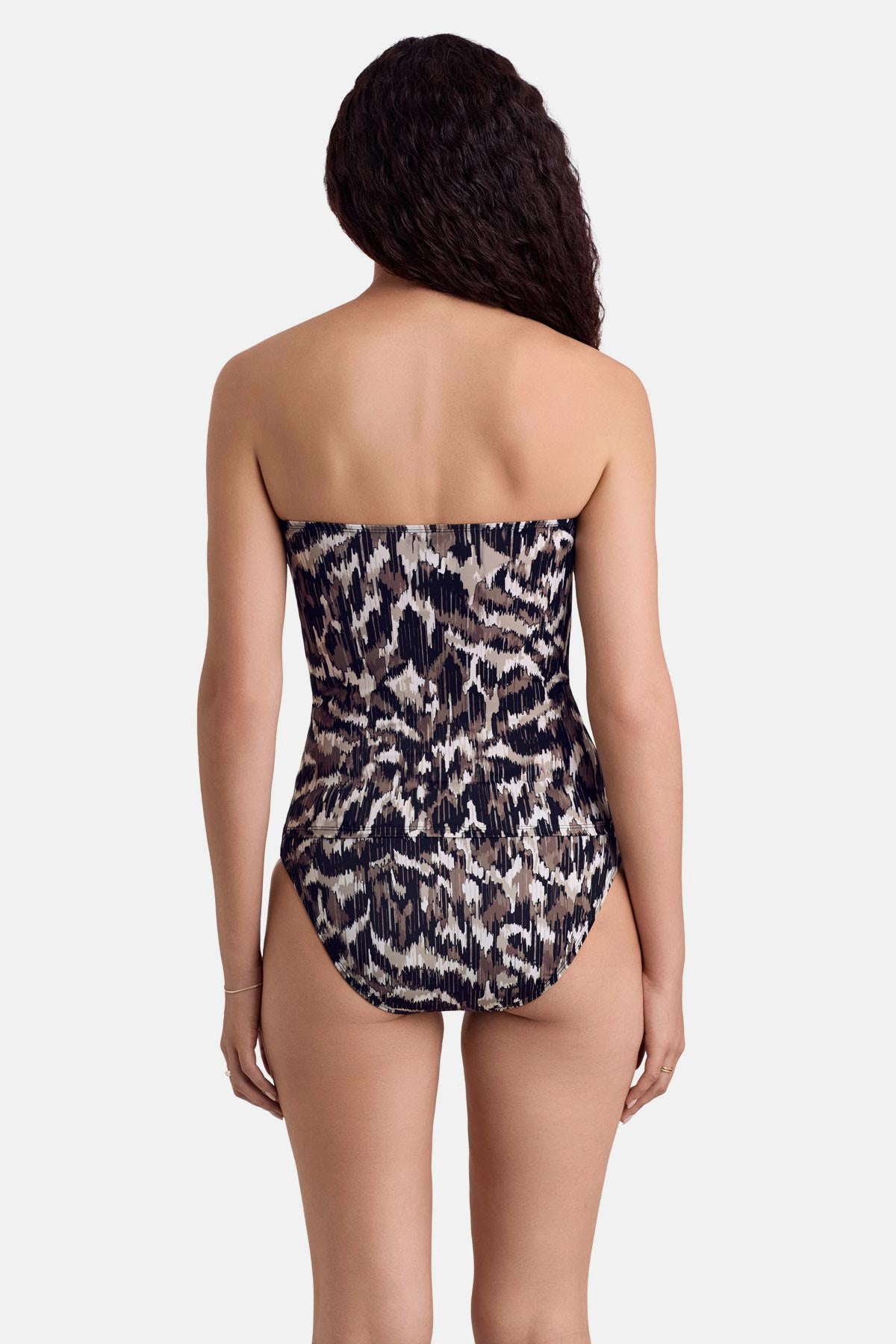 Woman faced away wearing an animal skin print bandeau tankini top with matching swim bottoms