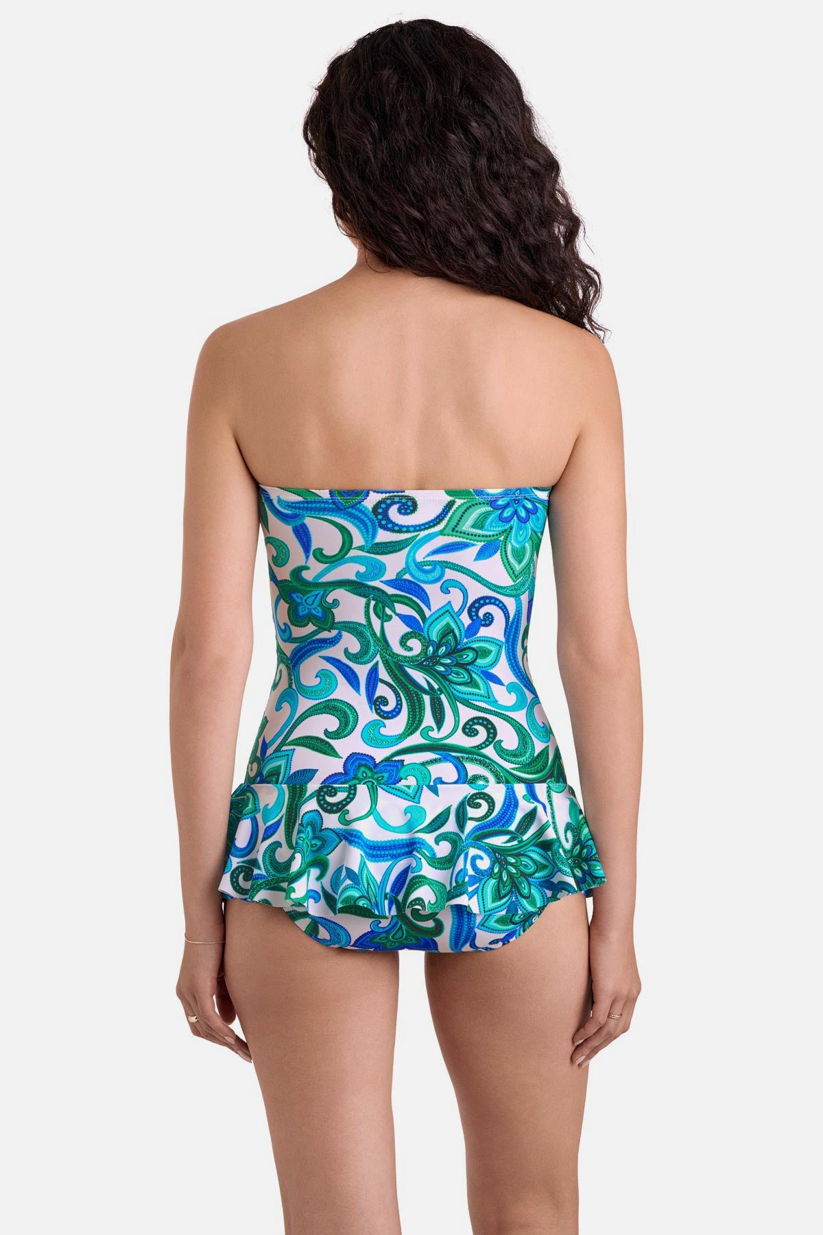 Woman turned away wearing a blue and green floral printed skirted one-piece swimsuit