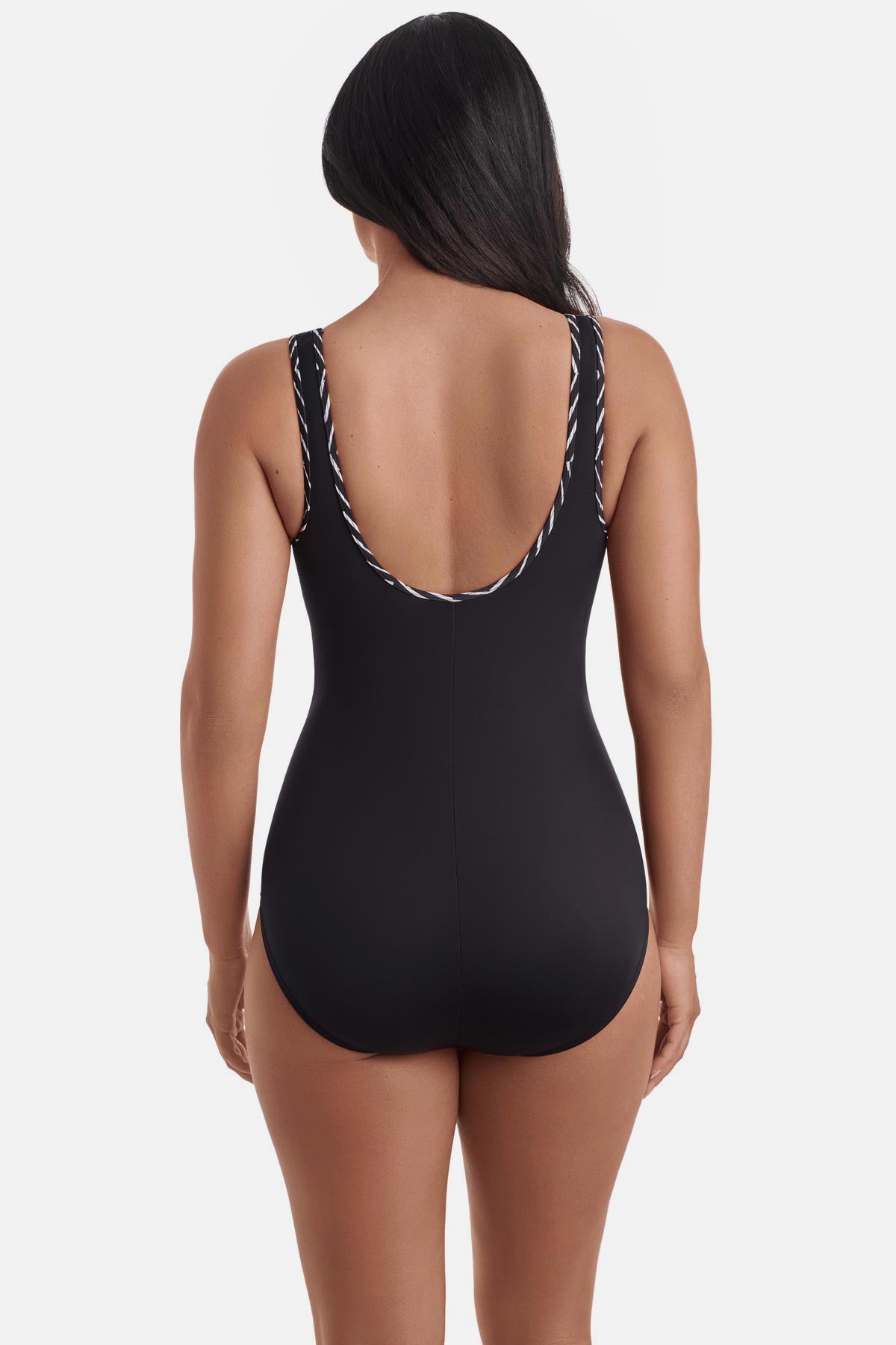 Woman turned away wearing a black one-piece swimsuit with black and white piping on the edges