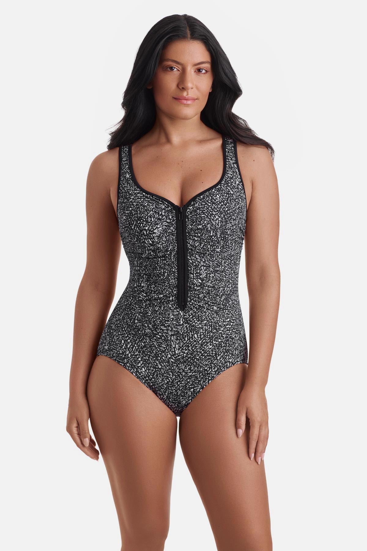 Woman wearing a black and white static print one-piece swimsuit with a zipper down the front