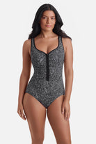 Woman wearing a black and white static print one-piece swimsuit with a zipper down the front