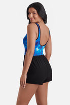 Woman turned left wearing a black and blue water print swim romper