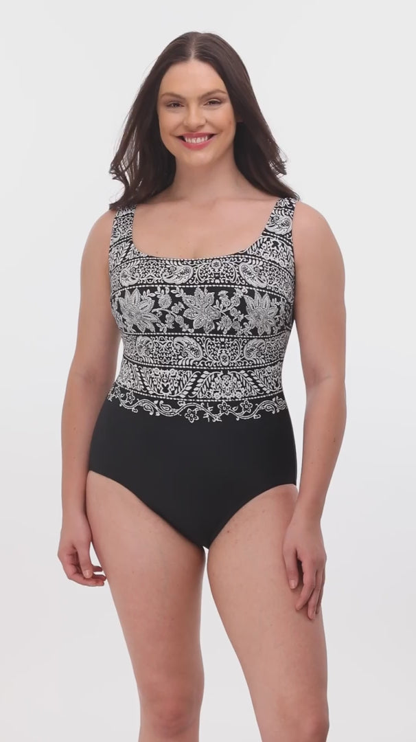 Woman wearing a black and white garland printed one-piece swimsuit