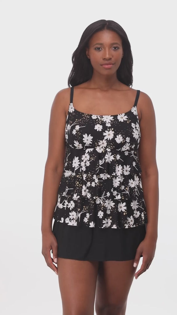 Woman wearing a black and white floral ruffled skirtini swimsuit