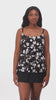 Woman wearing a black and white floral ruffled skirtini swimsuit
