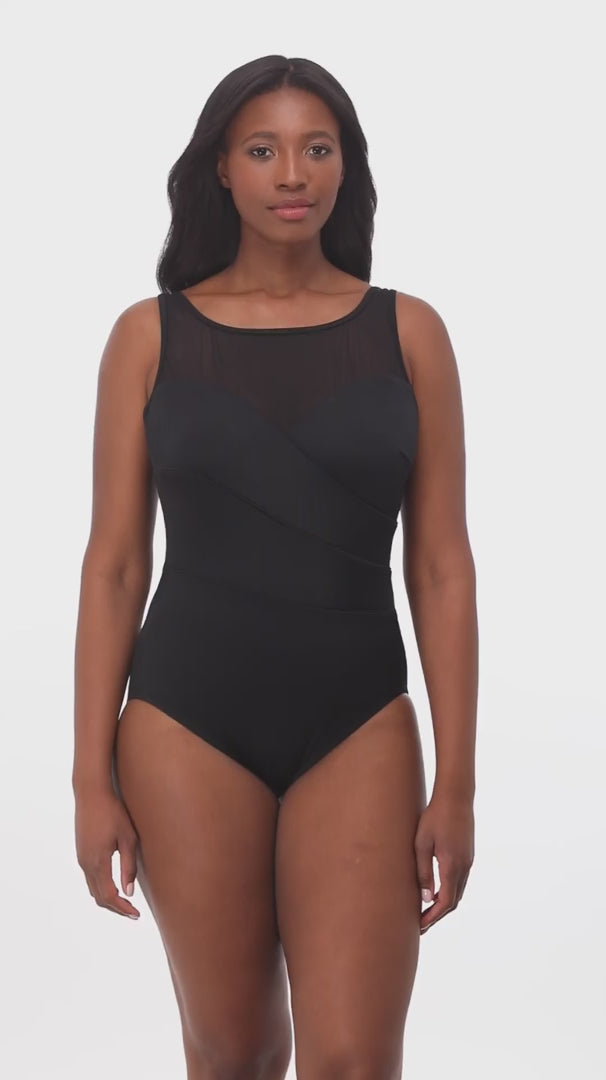 Woman wearing a black mesh high neck one-piece swimsuit