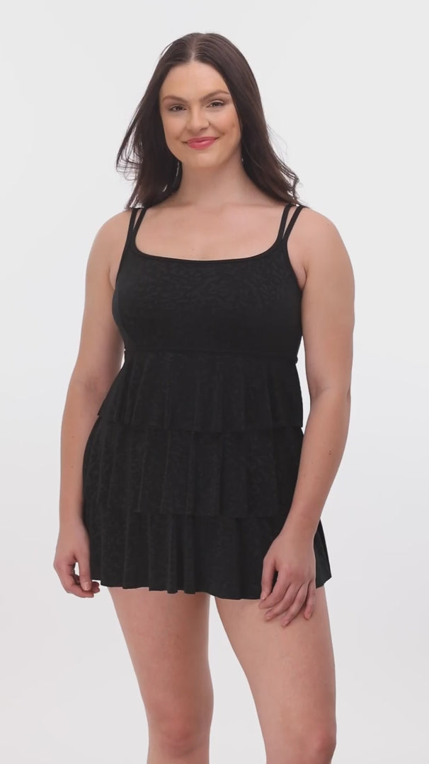 Woman wearing a black faint animal printed tiered swim dress