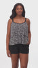 Woman wearing a black and white static pattern ruffle skirtini swimsuit