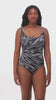 Woman wearing a black and white radial printed one-piece swimsuit
