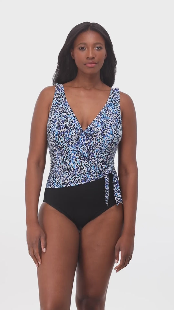 Woman wearing a blue dotted print ruffle neck one-piece swimsuit