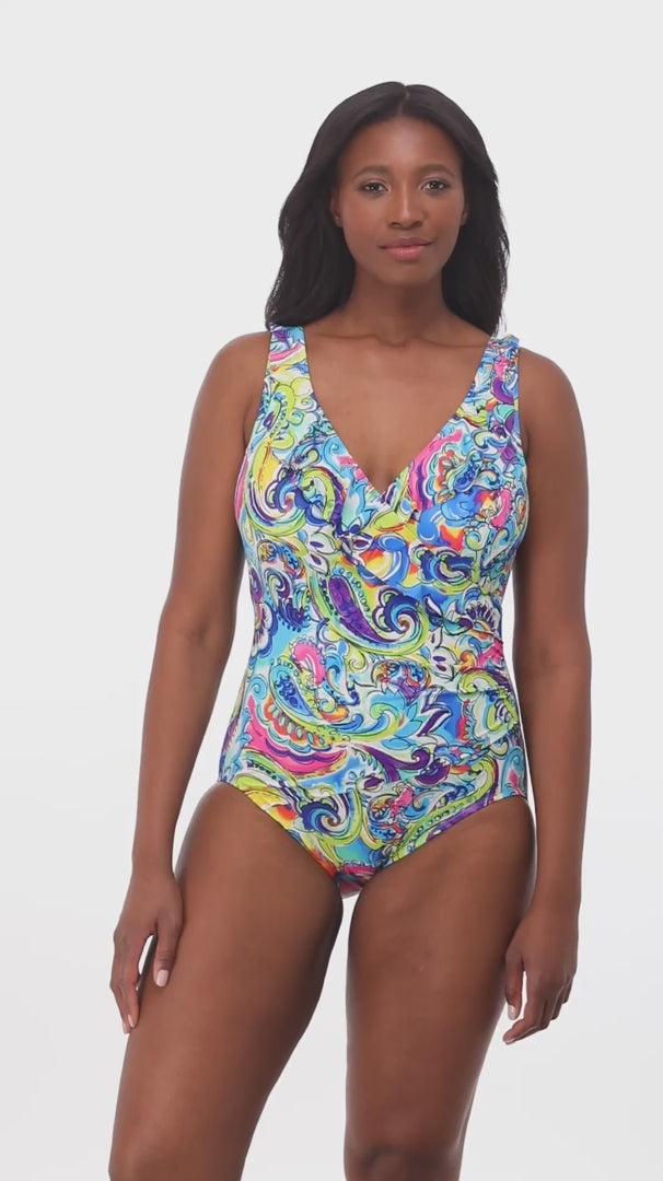 Woman wearing a brightly colored paisley print one-piece swimsuit