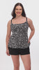 Woman wearing a black and white abstract printed ruffled skirtini swimsuit