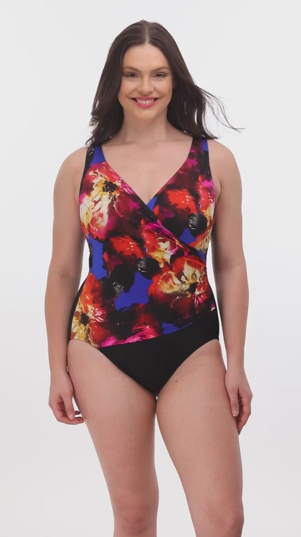 Woman wearing a multicolored watercolor one-piece swimsuit