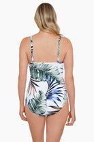 Woman faced away wearing a multicolored palm leaf printed one-piece swimsuit