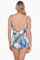 Woman faced away wearing a multicolored palm leaf printed one-piece swimsuit