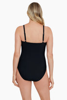 Woman turned away wearing a black one-piece swimsuit