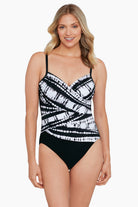 Woman wearing a black and white tie dyed one-piece swimsuit