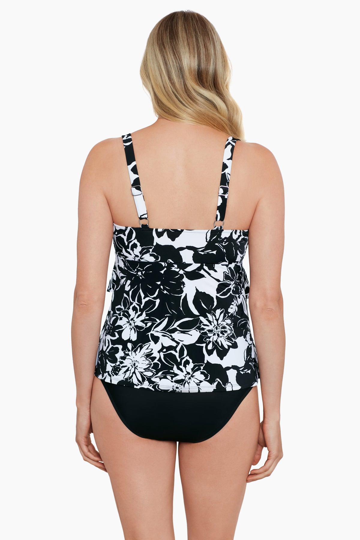 Woman turned away wearing a black and white floral pattern triple tier tankini top