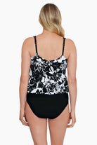 Woman faced away wearing a black and white floral pattern blouson ring tankini top
