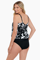 Woman turned left wearing a black and white floral pattern blouson ring tankini top