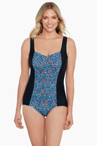Woman wearing a blue tile-esque printed one-piece swimsuit