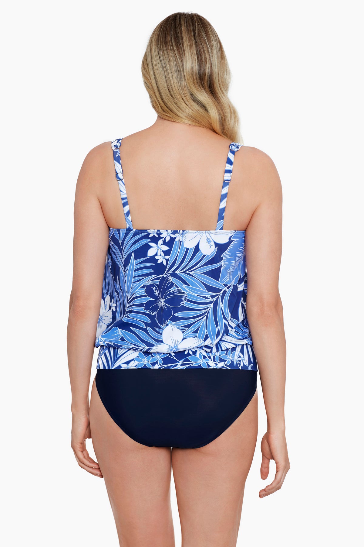 Woman faced away turned left wearing a blue and white tropical printed blouson tankini top