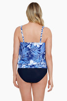 Woman faced away turned left wearing a blue and white tropical printed blouson tankini top