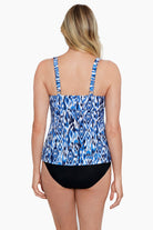 Woman turned away wearing a blue and white abstract printed triple tiered tankini top