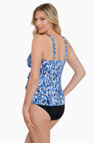 Woman turned left wearing a blue and white abstract printed triple tiered tankini top