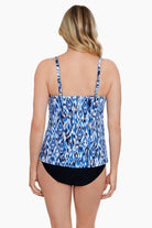 Woman turned away wearing a blue and white abstract printed cut away fauxkini one-piece swimsuit