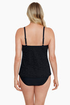 Woman faced away wearing a black with light animal print cut away fauxkini one-piece swimsuit