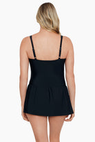 Woman turned away wearing a pink dotted pattern square neck skater swim dress