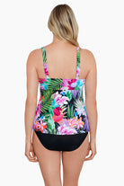 Woman turned away wearing a tropical printed tiered ruffle tankini top 