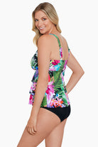 Woman turned left wearing a tropical printed tiered ruffle tankini top 