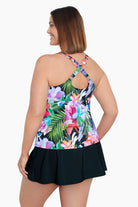 Woman turned left wearing a multicolored tropical print peep hole tankini top