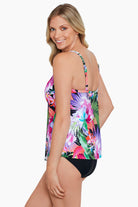 Woman turned left wearing a tropical printed middle split tankini top