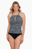 Woman wearing a black and white polka dot peep hole tankini top