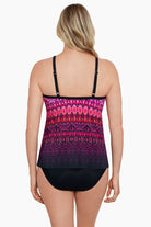 Woman faced away wearing a pink ombre and tile printed tankini top