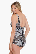 Woman turned left wearing a dotted leaf pattern one-piece swimsuit