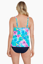 Woman turned away wearing a blue and pink floral printed cut away tankini top