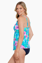 Woman turned left wearing a blue and pink floral printed cut away tankini top